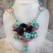 Blue Flowers Haute-Couture necklace embroidered with Swarovski crystals, a silk ribbon in Truffle/Raspberry color and seed beads